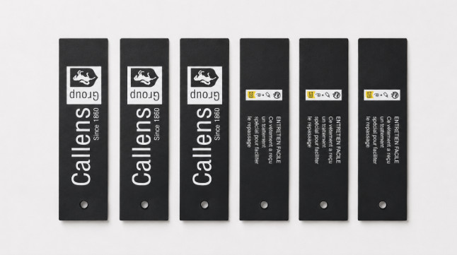 Black garment hang tags with the white Callens Group logo and care text